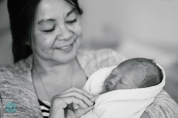 A grandmother smiles as she looks upon her grandbaby just minutes after her arrival.