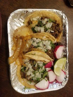 Carne asada tacos with grilled onions.