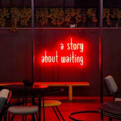 A fun neon light that says "A Story About Waiting"