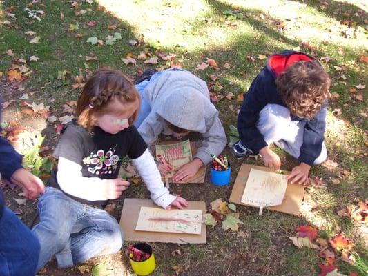 Children exercise their observation skills as they draw under the trees.