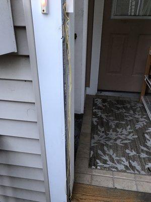 The wires left exposed from storm door installation after 4 months by Sal's Handyman services.