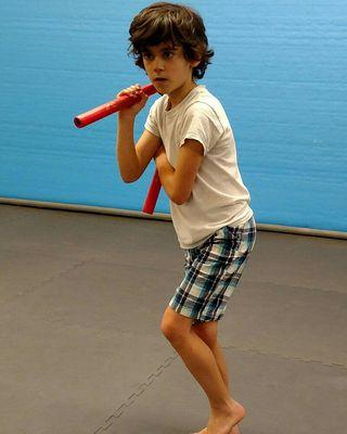 Wushu Belt student posing with Nunchucks