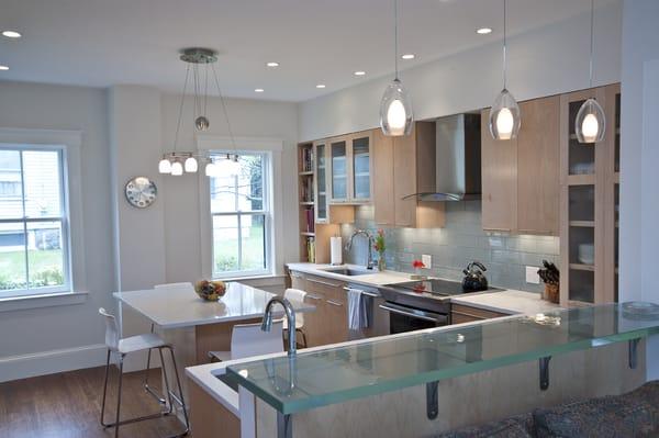 Modern kitchen makeover with ThinkGlass breakfast bar, specchio white HanStone engineered stone on island, and blizzard white no