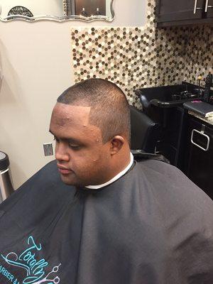 Even haircut all over, side burns to a slant and boxed/square in the back of the head.