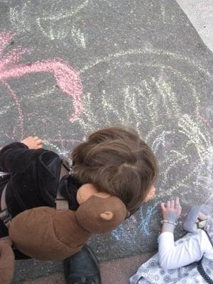 Children enjoying the free sidewalk chalk  given away at Arts Walk