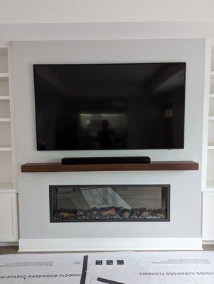 Walnut mantle with soundbar.