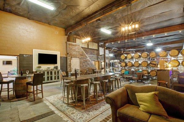 Our Urban Winery Tasting Room with a glimpse into the production side of winemaking past the barrels!