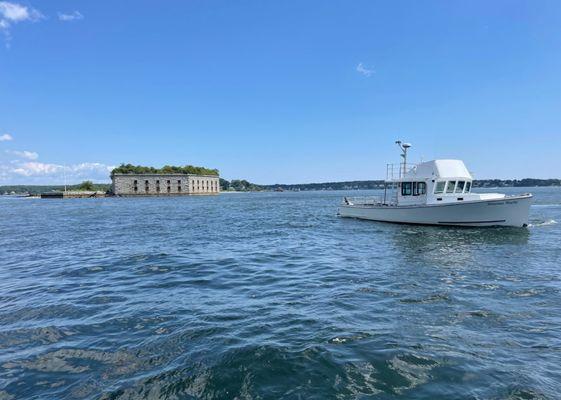 The Brianna Marie, an authentic lobster boat turned passenger vessel, cruising by historic Fort Gorges