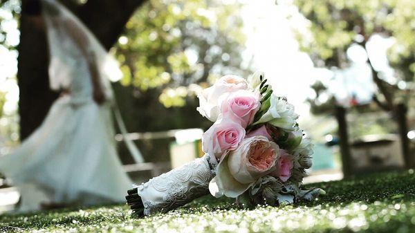 A screenshot of one of our wedding videos. Bride and her bouquet. Bride and groom were taking some photos at the venue.