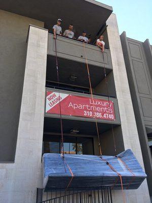 Movers hoisting large couch!