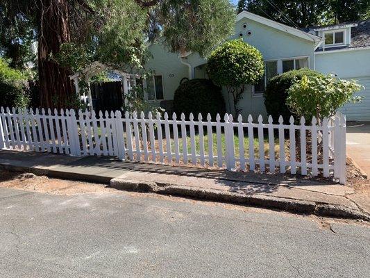 Picket, white fence, and New Concreate section of sidewalk