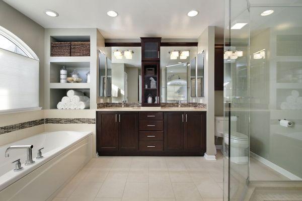 Modern master bathroom redesign with dark cabinetry and double vanities