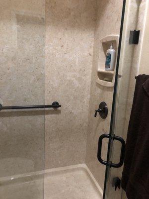 Glass shower door and controls on opposite end of shower head. So convenient.