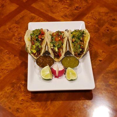 Tacos, meats include al pastor, chicken and beef.  Topped off with your choice of cilantro,  onion and salsa