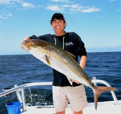 Teenager catching big Amberjack.