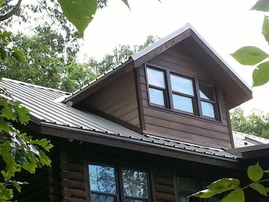 From this angle it is easy to see how well a metal roof can compliment a log cabin.  The combination provides an ideal blend ...