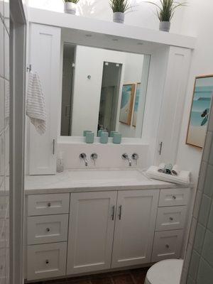 Bathroom vanity,shaker doors, spray-painted, wall mounted double faucet, quartz countertop and backsplash, built-in mirror and led lights.