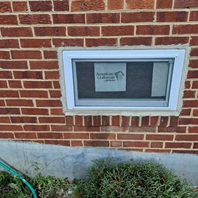 Installation of small hopper basement window.