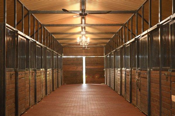 13-stall barn with rubber paver aisle, ceiling fans and chandelier.