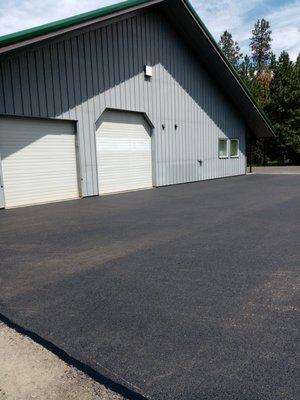 New asphalt pad, sloped for drainage.