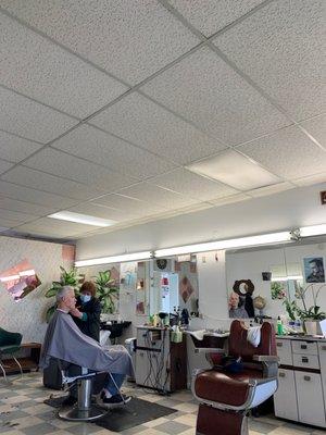 Lady cutting man's hair