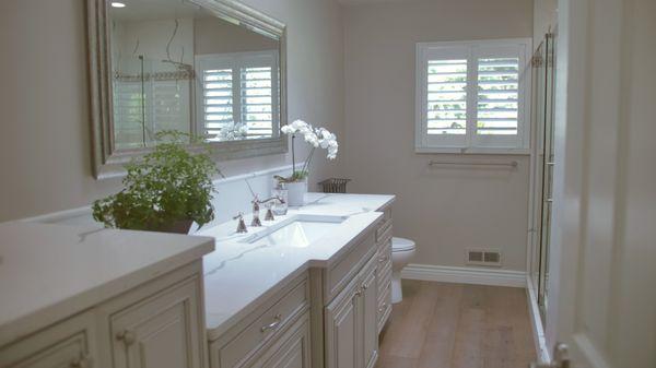 This clean, white bathroom features a marble countertop, and we kept things consistent by including marble in the shower as well.