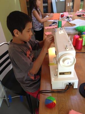 Camper learns how to thread a sewing machine at Jumbo Jibbles Sewing Camp.