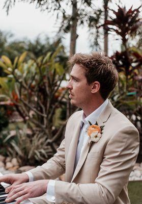 Groom playing piano at ceremony