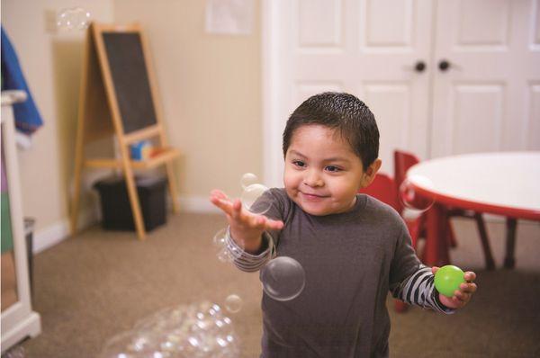 Andres, diagnosed with autism, plays with bubbles.