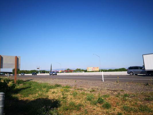 Across the freeway.  Old signage would make me question if this place is even open.