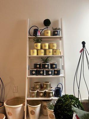 Shelf with pots in multiple colors: navy, green, and yellow