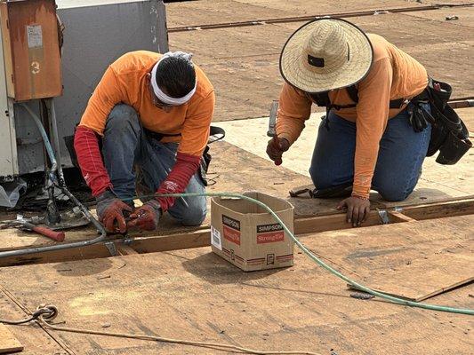 Workers replacing wood prior to re-roof work