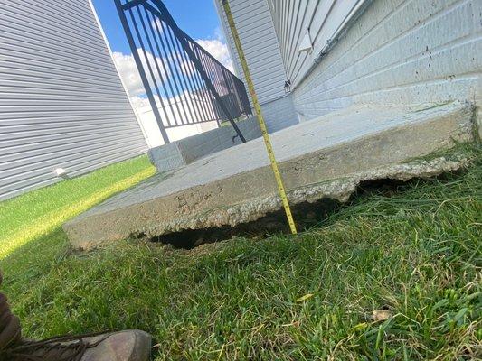 Another view of the areaway sinkhole.  A full 9" below the top of the landing to the top of the grass. But the sinkhole is another 2" below.