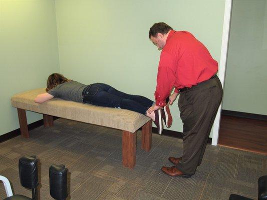 Dr. Patrick Anderson DC performing a leg check on a patient after she was scanned