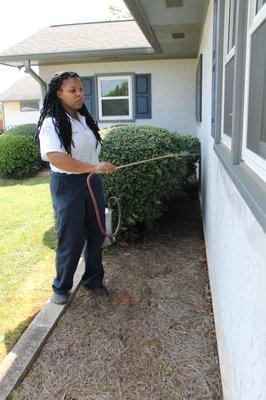 Spraying around a window for pest control.