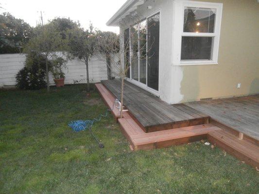 Same back yard deck with new steps surrounding the deck.