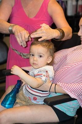 Sitting on mom's lap, Carson having his first haircut