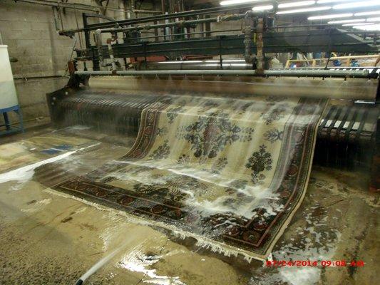 Handmade area rug being rinse after washing and scrubbing .