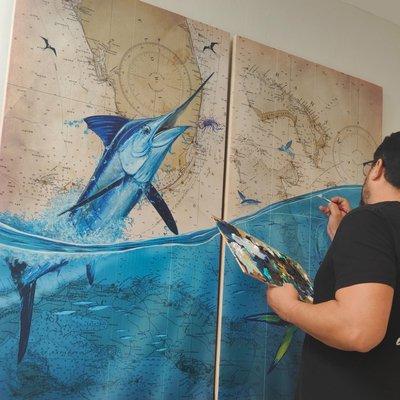 Artist Eddie Forbes hand embellishing custo Marlin and Mahi coastal chart prints on wood (2 piece set)