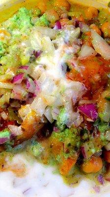 Samosa Chaat: 2 flavorful samosas, topped with chick peas, tamarind sauce, green sauce, yogurt and onions.