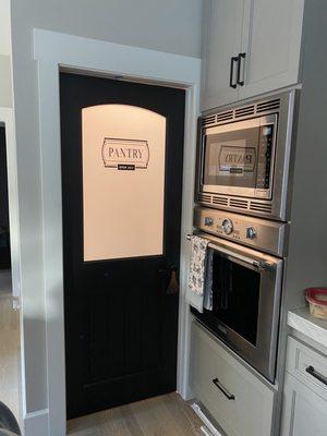 Custom pantry door, custom cabinetry with Thermador wall oven/microwave combo