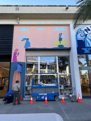 26' electric scissor lift on site in front of store.