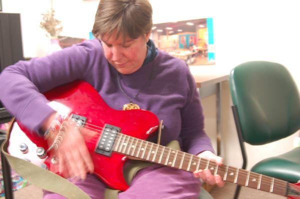 Mary Beth Frampton jamming on a guitar in music studio