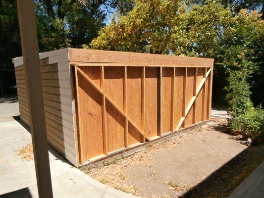 Rear wall of carport with new wall framing and SIZMIC ANGLE BRACING ADDED.