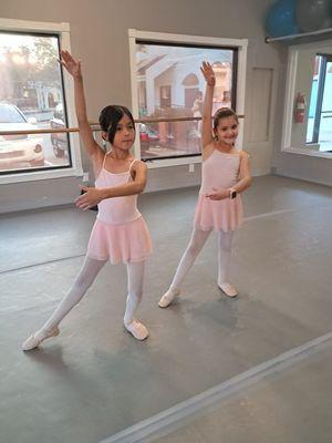 This picture shows two little girls happily dancing ballet at Art & Dance Studio in San Antonio, Texas.