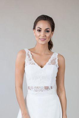 This top features a v-neck bodice and v-back with a scallop edge finish.