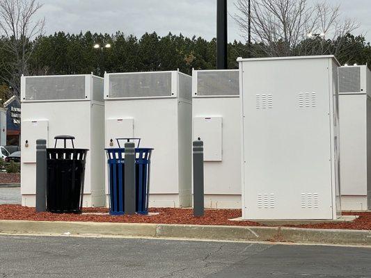 Trash and recycle cans located on the left side of the charging spots.