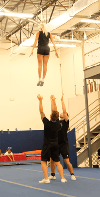 Flying high! In this picture you see our clinic coaches teaching our athletes to stunt safely.