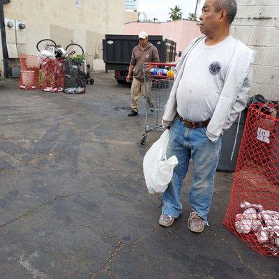 Here is the recycling guy walking back with his money.