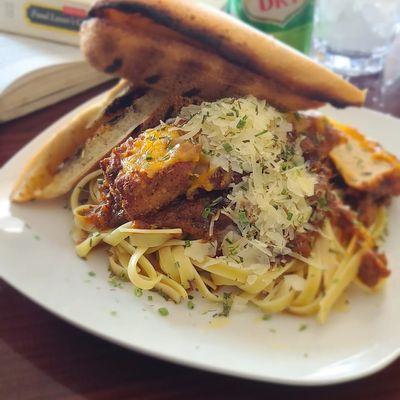 UNKOMMON CHICKEN Parmesan over FETTUCCINE  WITH THE RICHEST  8hr Pomodoro (red sauce)
Garlic bread and a salad